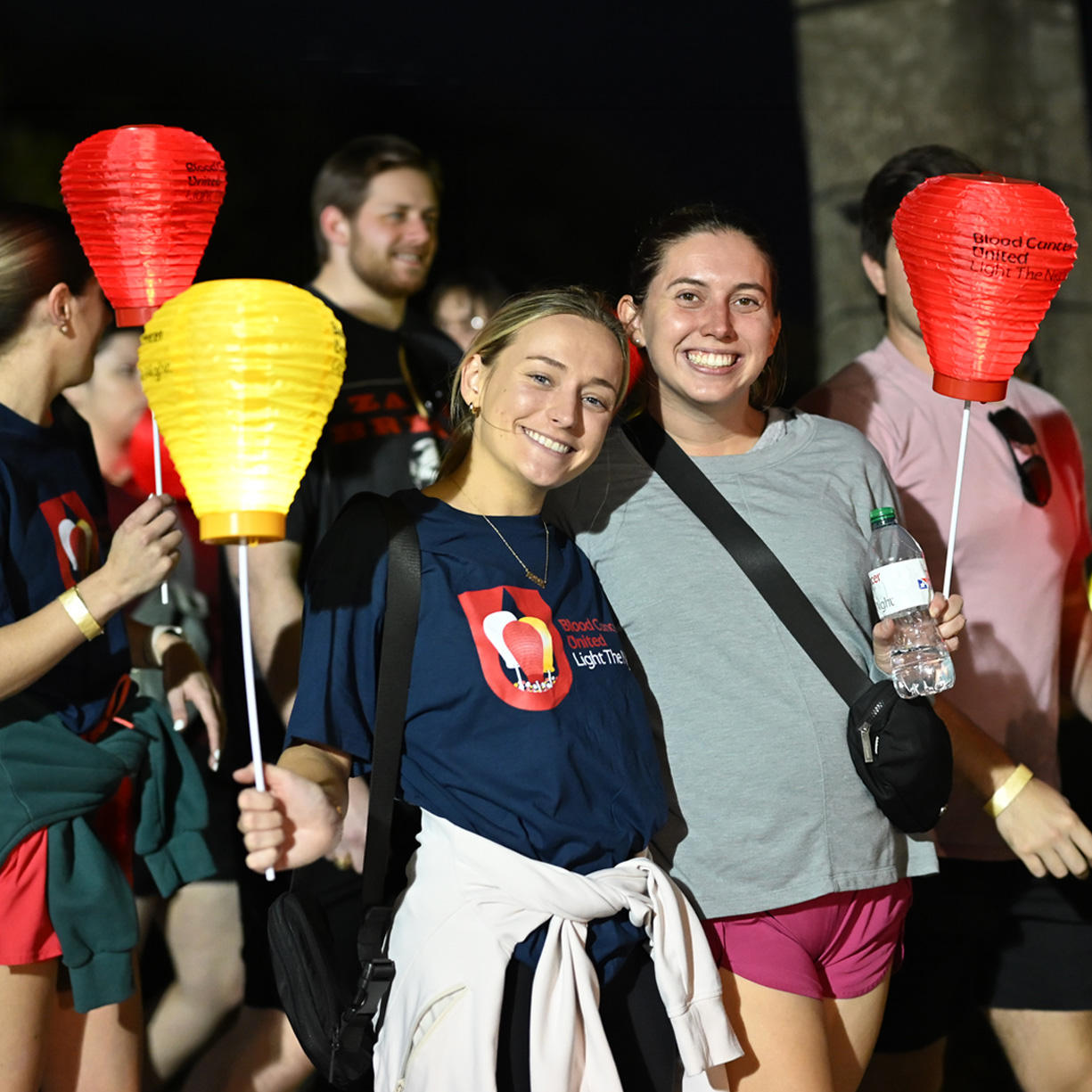 survivor participant at a Light The Night event standing holding white lantern and her family 